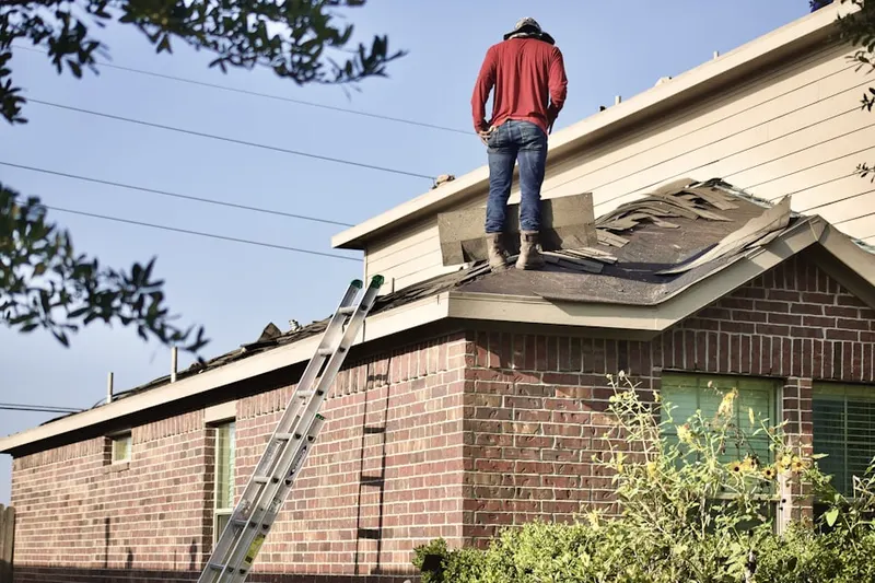 Professional roofer working on a residential roof in Sanders Prairie